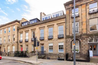 a large brick building on the corner of a street at JOIVY Spacious Apartment close to Princes Street in Edinburgh