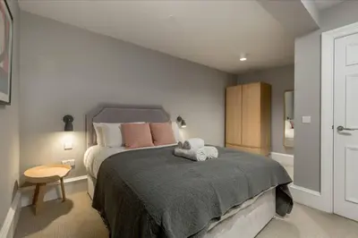 a bedroom with a bed with a stuffed animal on it at JOIVY Luxurious Home near Haymarket Station in Edinburgh