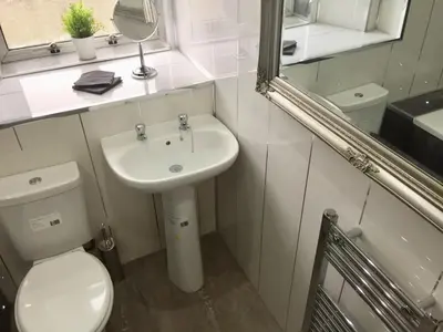 a bathroom with a toilet and a sink and a mirror at RIVER CLYDE VIEWS - PRIVATE & SPACIOUS APARTMENT in Port Glasgow