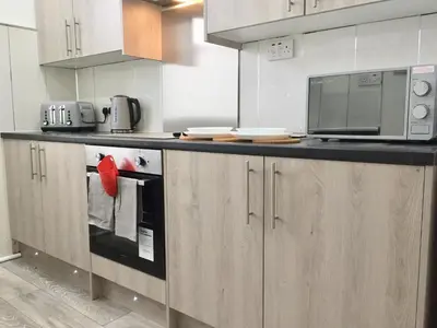 a kitchen with a counter with a microwave and a stove at RIVER CLYDE VIEWS - PRIVATE & SPACIOUS APARTMENT in Port Glasgow
