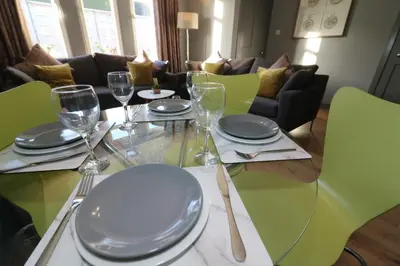 a table with plates and wine glasses on it at Signature - Burnbank House in Hamilton