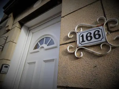 a door to a building with a sign on it at Signature - Burnbank House in Hamilton