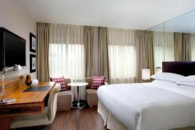 a hotel room with a large bed and a desk at Sheraton Grand Hotel & Spa in Edinburgh
