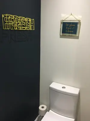 a bathroom with a toilet and a sign on the wall at The Torfin in Edinburgh