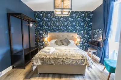 a bedroom with a bed and a blue wall at The Torfin in Edinburgh