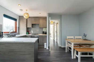 a kitchen with a table and a dining room at One Bedroom ground floor flat in Stirling