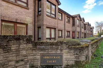 a stone retaining wall in front of a building at One Bedroom ground floor flat in Stirling