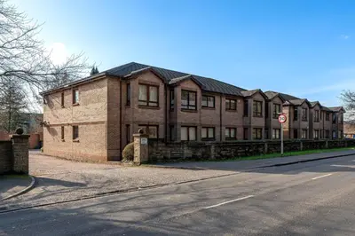 a large brick building on the side of a street at One Bedroom ground floor flat in Stirling