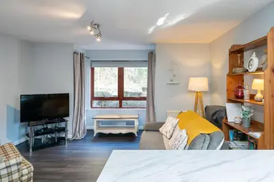 a living room with a couch and a tv at One Bedroom ground floor flat in Stirling