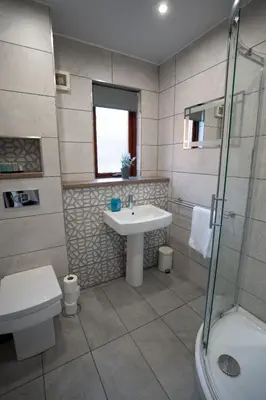 a bathroom with a sink and a toilet and a shower at One Bedroom ground floor flat in Stirling