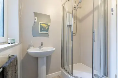 a bathroom with a sink and a glass shower at Ground-fl Two Bedroom Apartment in Bridge of Allan in Bridge of Allan