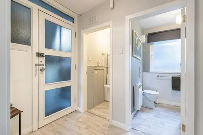 a white bathroom with a toilet and a window at Ground-fl Two Bedroom Apartment in Bridge of Allan in Bridge of Allan