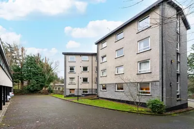 an empty street in front of an apartment building at Ground-fl Two Bedroom Apartment in Bridge of Allan in Bridge of Allan