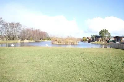 a view of a river with two swans in the water at Jackson Lodge in Perth