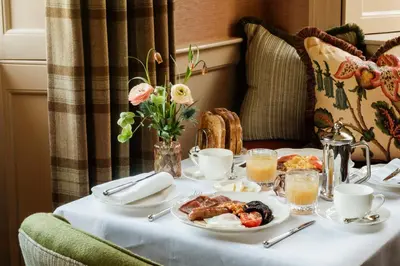 a table with a plate of breakfast food on it at The Fortingall in Kenmore