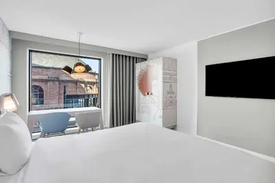 a white bedroom with a large bed and a television at Radisson RED Hotel, Glasgow in Glasgow