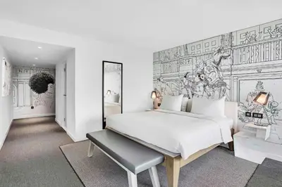 a bedroom with a large white bed and a mural at Radisson RED Hotel, Glasgow in Glasgow