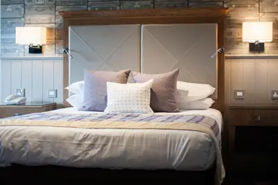 a bedroom with a large bed with two lamps at Seamill Hydro Hotel in Seamill