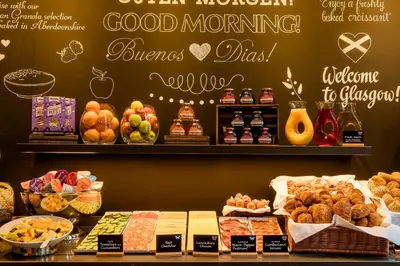 a bakery with a bunch of different types of food at Motel One Glasgow in Glasgow