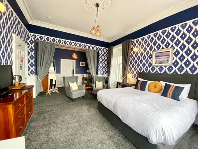 a bedroom with a large bed and blue and white walls at Barriemore Oban in Oban