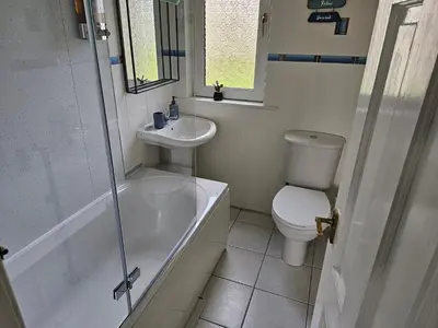 a bathroom with a toilet and a sink and a shower at Snug - Meadhan Apartment in Helensburgh