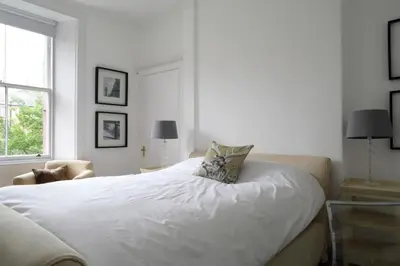 a white bedroom with a bed and a window at Stylish 2 Bedroom Bruntsfield Apartment in Edinburgh in Edinburgh