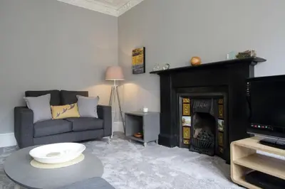 a living room with a couch and a fireplace at Stylish 2 Bedroom Bruntsfield Apartment in Edinburgh in Edinburgh