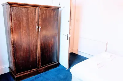 a wooden cabinet in a room with a door at Traditional Apartment oer the Meadows in Edinburgh