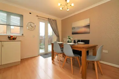 a dining room with a table and chairs and a clock at Signature - Angus House Glasgow in Glasgow