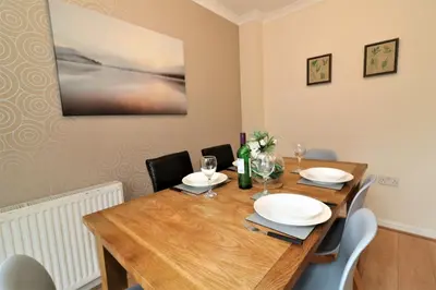 a dining room with a wooden table and chairs at Signature - Angus House Glasgow in Glasgow