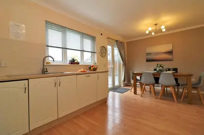 a kitchen with a sink and a table with a dining room at Signature - Angus House Glasgow in Glasgow