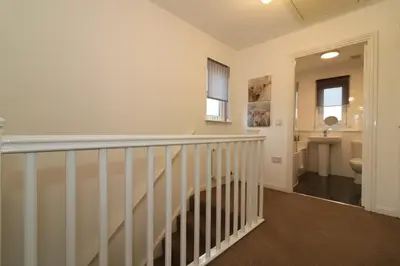 a hallway with a staircase leading to a bathroom at Signature - Angus House Glasgow in Glasgow