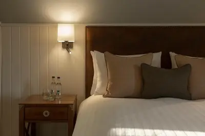 a bedroom with a bed and a table with glasses on it at The Glencoe Inn in Glencoe