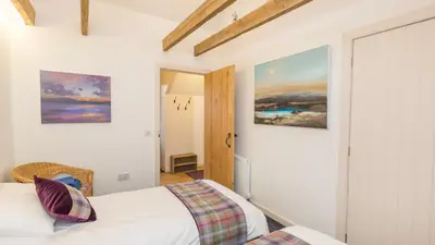 a bedroom with a bed and paintings on the wall at Hayloft Edinburgh in Edinburgh