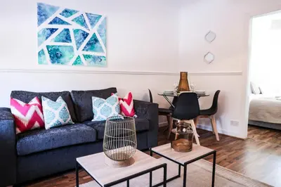 a living room with a couch and a table at Meadowburn View in Wishaw