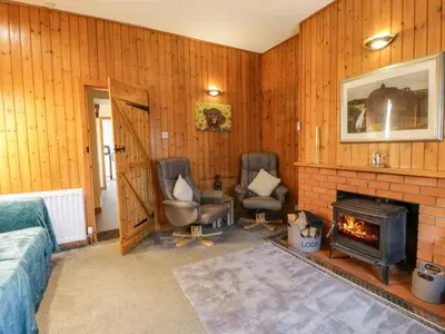 a living room with two chairs and a fireplace at Rose Cottage in Stranraer