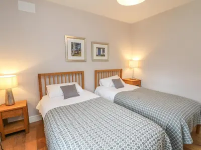 two beds sitting next to each other in a bedroom at Holly Cottage in Glencoe