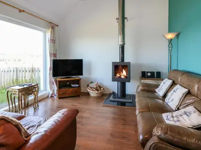a living room with a couch and a fireplace at Starfish Cottage in Craignure