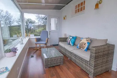 a living room with a couch and a chair at Craigievern Cottage in Drymen