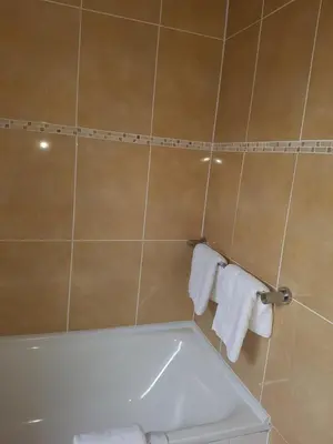 a bathroom with a tub and a toilet and towels at Ardshiel Hotel in Campbeltown