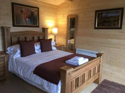 a bedroom with a bed in a log cabin at Auchenlea lodges in Glasgow