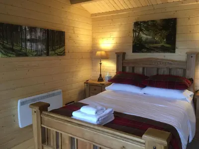 a bedroom with a bed in a log cabin at Auchenlea lodges in Glasgow