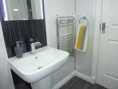 a bathroom with a white sink and a mirror at Paisley Central Apartment #2 in Paisley