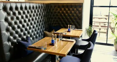 two tables in a restaurant with a leather wall at The Douglas Hotel in Brodick