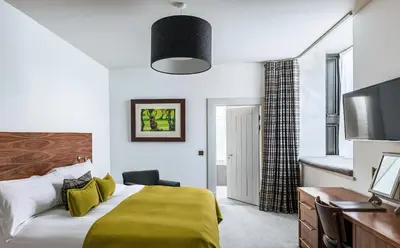 a hotel room with a bed and a television at The Douglas Hotel in Brodick
