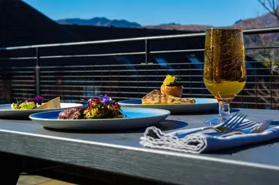 a table with plates of food and a glass of wine at The Douglas Hotel in Brodick