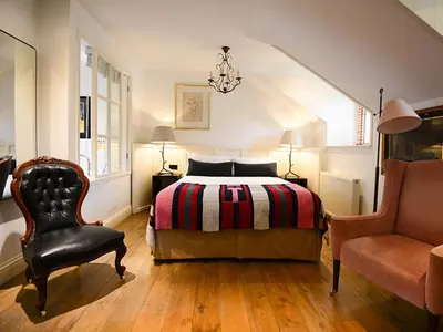 a bedroom with a bed and a chair at Monachyle Mhor Hotel in Lochearnhead