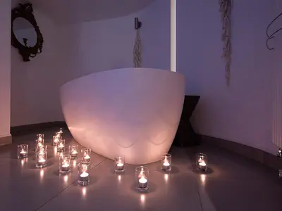 a large white bowl with lit candles on a table at Monachyle Mhor Hotel in Lochearnhead