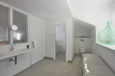 a white bathroom with a couch and a sink and a toilet at Monachyle Mhor Hotel in Lochearnhead