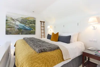 a bedroom with a large bed and a painting on the wall at Monachyle Mhor Hotel in Lochearnhead